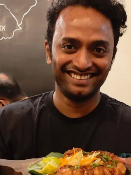 A happy customer from the foodie group, proudly holding up a platter of our crispy pork. Seeing our guests enjoy our food is the greatest reward.