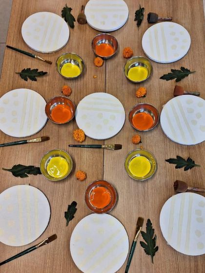 This art invitation is prepared with symmetry and beauty in mind. Circular canvases, bowls of paint, and natural elements are arranged to be aesthetically pleasing, communicating to the child that their work and materials are valued.