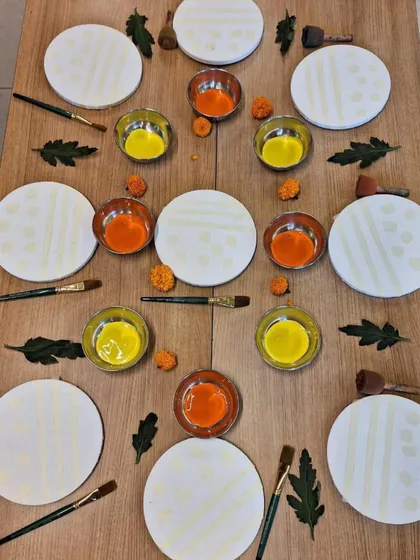 This art invitation is prepared with symmetry and beauty in mind. Circular canvases, bowls of paint, and natural elements are arranged to be aesthetically pleasing, communicating to the child that their work and materials are valued.