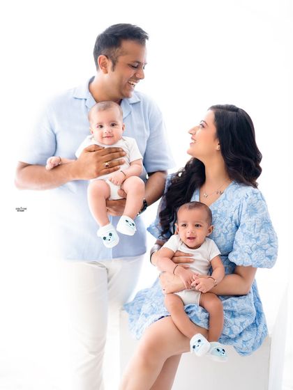 A beautiful family of four, with each parent holding one of their adorable twin babies.