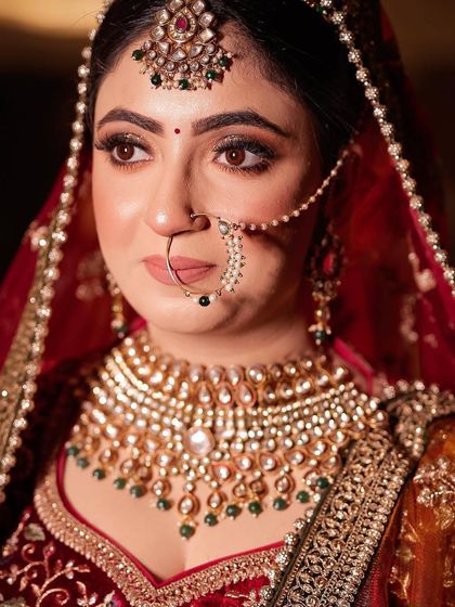 A close-up of the bride's face, highlighting her beautiful nath and heavy choker.