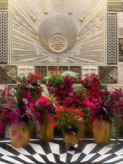 The checkerboard floor and gilded wall are the perfect dramatic backdrop for these lush, jewel-toned floral arrangements.