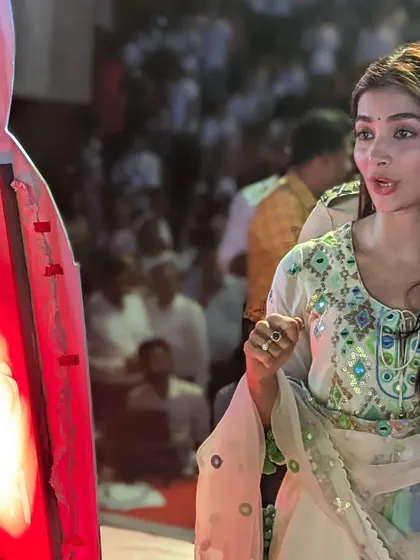 Actress Pooja Hegde taking a closer look at the sand art lightbox after the show.