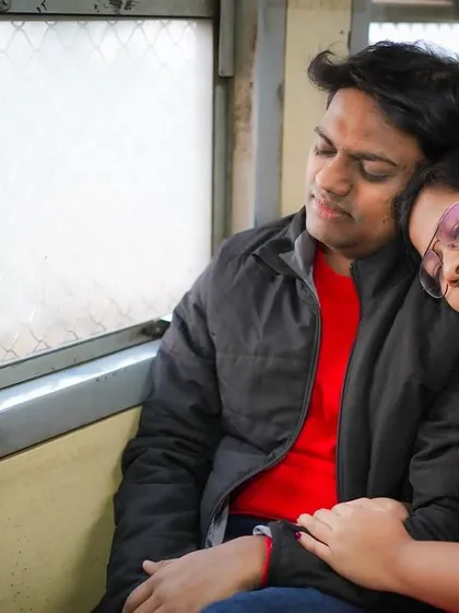 A peaceful moment of rest on a journey together. This image captures a sense of comfort and trust, telling a story of finding home in one another, even on a bustling Mumbai local train.