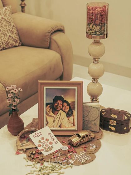 A personalized corner with a framed photo, a vintage car model, and a card that says "Pyaar, Kadhal," meaning love in two languages.