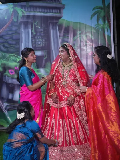 A candid moment of the bride with her bridesmaids and family as they help her get ready. These photos capture the love and support surrounding the bride on her big day.