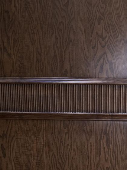 A detail shot of the fluted band on the ash wood door, showcasing the precision of the CNC carving.