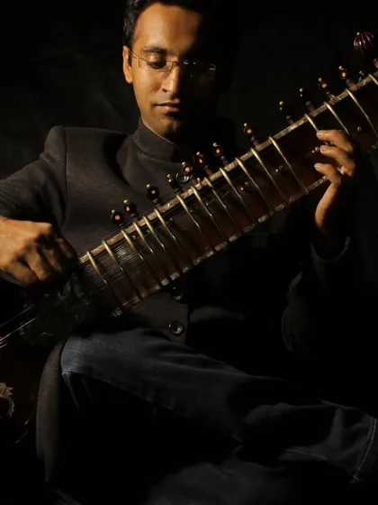 A full-length studio portrait in a dark, contemporary style.
