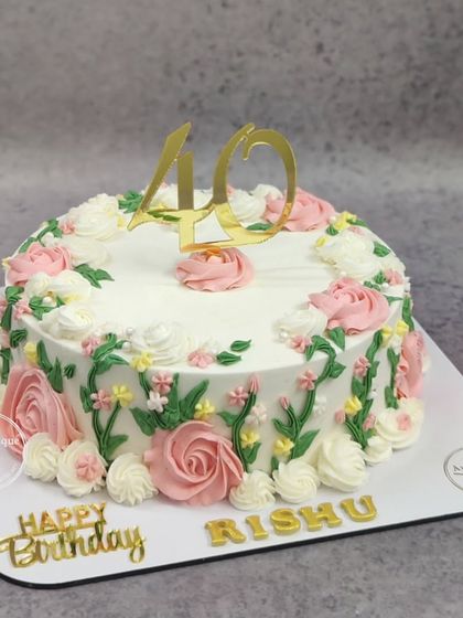 A vintage spring floral cake for a 40th birthday. The cake is adorned with beautifully piped pink and white roses and green leaves.