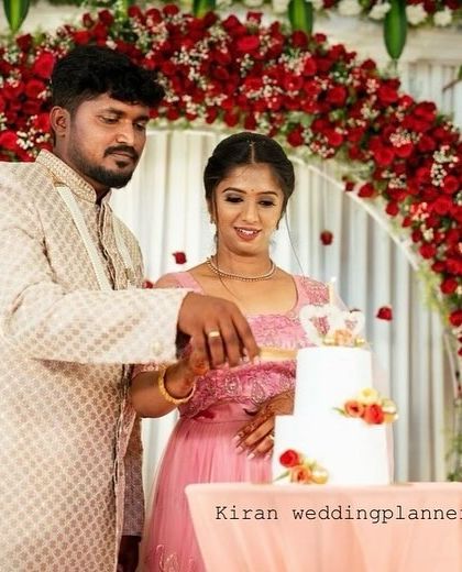 A close-up of the cake-cutting ceremony, showing the beautiful details of the floral arch and the couple's happiness.