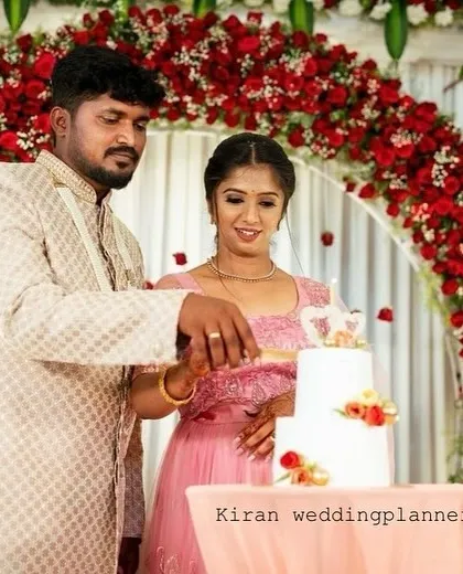 A close-up of the cake-cutting ceremony, showing the beautiful details of the floral arch and the couple's happiness.