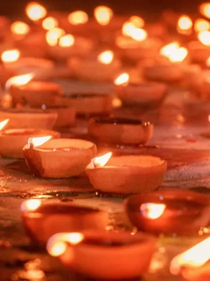 A close-up shot of countless diyas, their flames creating a warm, golden glow. This image symbolizes the light and hope of the festival.