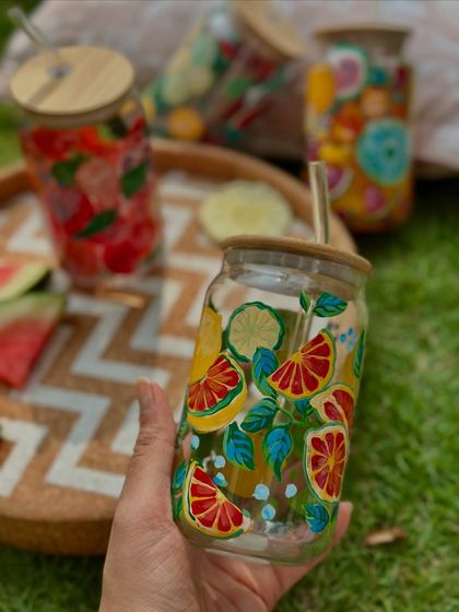 Holding our citrus-themed glass sipper. The hand-painted lemons and grapefruits look so fresh and vibrant, you'll want to drink more water just to use it.