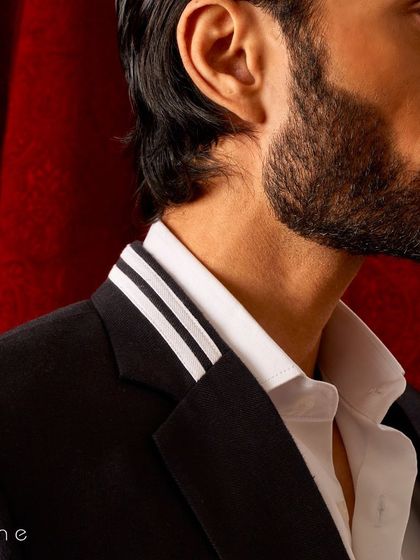 A detailed shot of the collar on our modern black blazer, where two clean white stripes add a graphic, contemporary feel.
