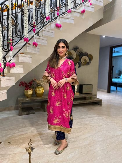 A full-length shot of my self-designed Diwali outfit. The combination of the bright pink kaftan with navy blue pants is both modern and traditional.