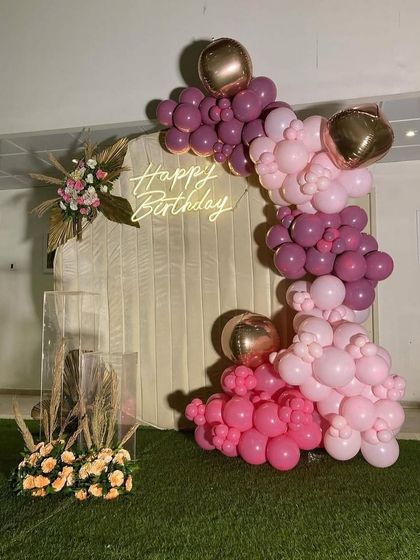 A closer look at the boho-chic backdrop, highlighting the texture of the fabric and the shades of the pink balloons.