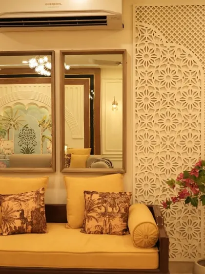 This seating area uses traditional Indian 'jaali' or latticework panels on the walls to create a beautiful, textured backdrop. The simple wooden divan with yellow upholstery adds a pop of color and classic charm.