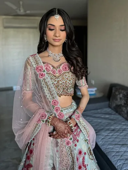 Soft elegance for Khushali's event. Her makeup features gentle pink tones and a dewy finish, perfectly paired with her stunning Gazal Gupta blue floral outfit.