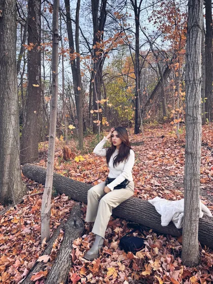A candid moment sitting on a log in a forest filled with fall foliage at Blue Mountain.