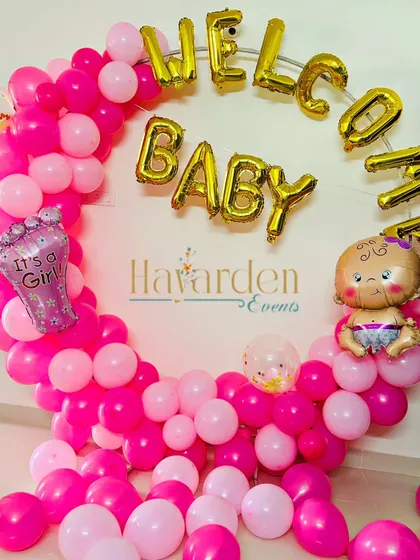 A 'Welcome Baby' ring decoration in vibrant pink. The 'It's a Girl' foil balloon and baby-themed accents make this a joyful welcome.