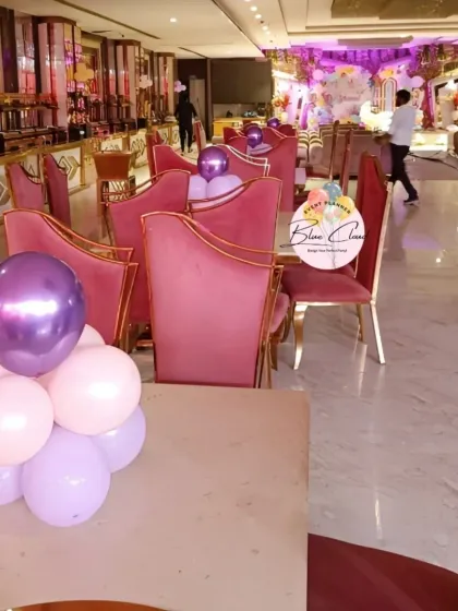 Simple balloon centerpieces on tables in a large party hall.