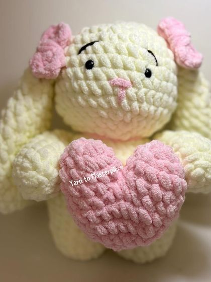 A front view of the plush bunny holding a heart.