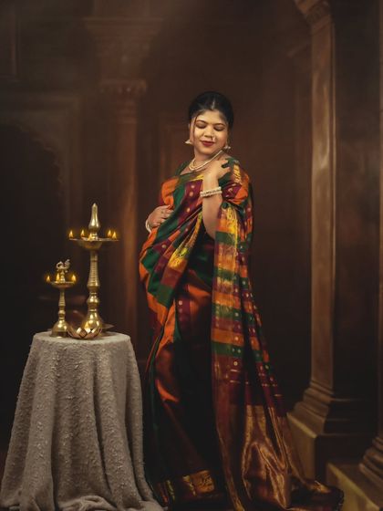 An elegant solo portrait of the mom-to-be, her colorful saree beautifully complementing the vintage-style backdrop.