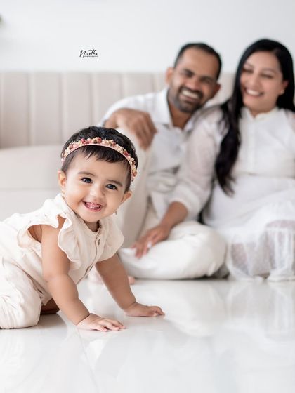 A happy baby girl crawling on the studio floor.