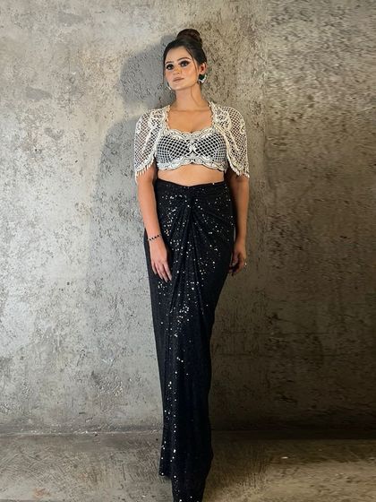 A client looking radiant in a black festive-ready ensemble, featuring an exquisitely embellished waistcoat and draped skirt.