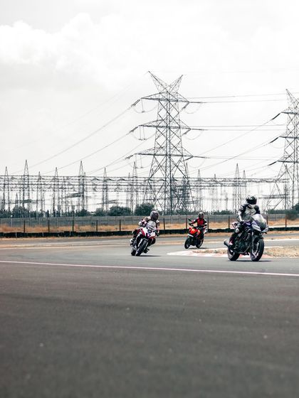 Riders on the track with power lines in the background, an iconic view from the CoASTT circuit.