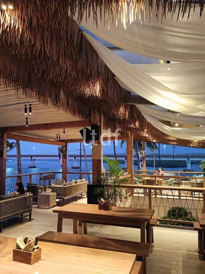 The upper deck of ISSA Goa, with its hay-covered roof and flowing white drapes, creates a dynamic look that interacts with the riverside winds. The design offers a panoramic dining experience that is both rustic and luxurious.