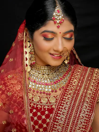 Showcasing my versatility with a North Indian bridal makeup look. This features a bold red and gold color palette with dramatic eye makeup, designed to match the ornate lehenga and jewelry.
