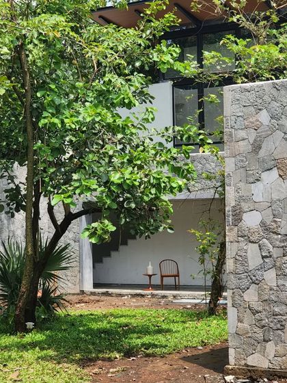 A quiet moment at 'Villa 16', where a single chair sits in a covered outdoor space. The design creates many such pockets for solitude and reflection.