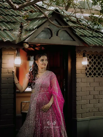 The bride-to-be looking elegant and poised in her pink lehenga, ready for her engagement celebration.