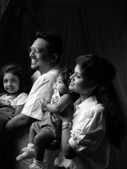 A candid black and white shot of a family looking off-camera, capturing a natural and unposed moment together.