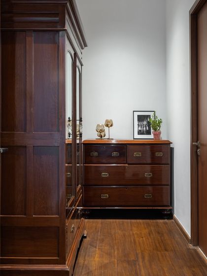 A corner of a bedroom featuring beautiful wooden furniture. The rich tones of the wood add warmth and a sense of timeless quality to the space.