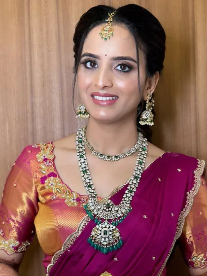A smiling portrait of Chandana, showcasing her engagement makeup. I used a soft pink and gold palette on the eyes and a radiant base to complement her magenta and gold saree.