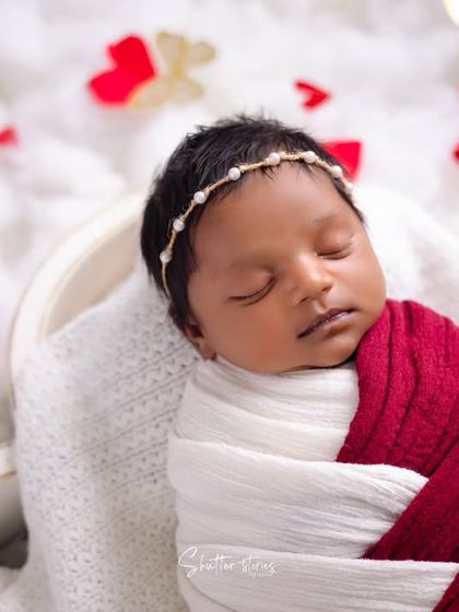 A close-up detail from the love-themed shoot, focusing on the baby's serene face and the delicate pearl headband. Close-ups are essential for a complete client gallery.