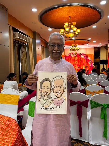 An elegant guest holding a couple's caricature in a beautifully decorated wedding hall. These portraits make for fantastic and personal return gifts.