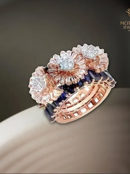 A modern architectural design. This ring features three floral diamond clusters set atop bands of deep blue sapphires and sparkling diamonds, a testament to our innovative craftsmanship.