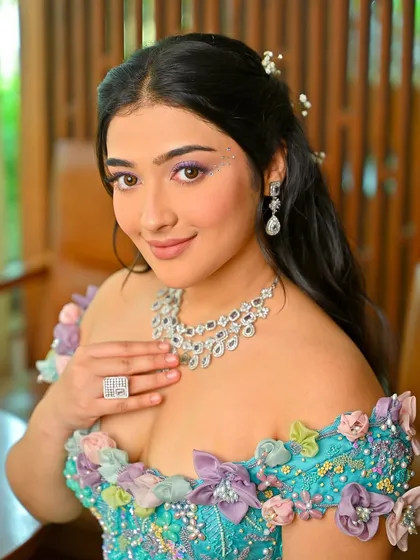 Another portrait from this creative shoot. The half-up hairstyle is adorned with delicate, baby's breath-like accessories, adding to the fairytale vibe.