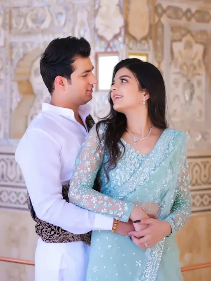 An intimate pre-wedding portrait where the couple's connection is the central focus. The soft lighting and the historic architecture in the background add a timeless, romantic quality to this candid photography moment.