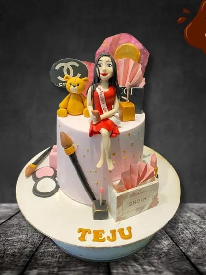 This cake is all about glamour and style. It's decorated with fondant makeup items, shopping bags from brands like Chanel and Shein, and a stylish figure of the birthday girl.