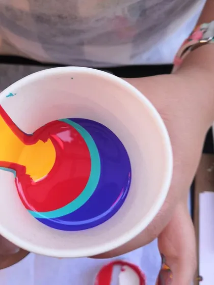 The moment before the pour. Layering different acrylic paint colors in a cup is the first step to creating a unique, multi-colored abstract design.