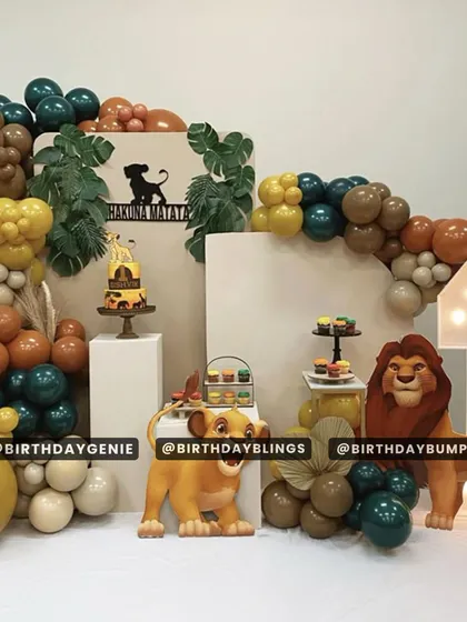 A stylish "Hakuna Matata" setup with a muted color palette of mustard, brown, and dark green balloons. This design features multiple plinths for desserts and a light-up number '1' for a modern first birthday celebration.