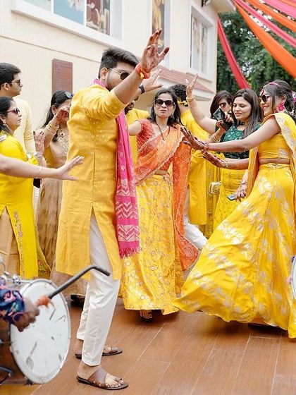 The groom's grand entrance at the Haldi, surrounded by friends, family, and the energetic beats of dhol drummers. We ensure every moment is a celebration, filled with dance and excitement.