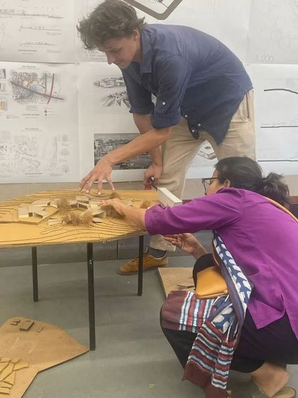 Another juror and I closely examining a student's model. These detailed critiques are an essential part of architectural education, providing specific and actionable feedback.