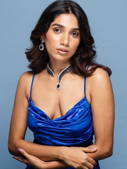 A three-quarter portrait of the model in the blue satin dress, with a confident pose.
