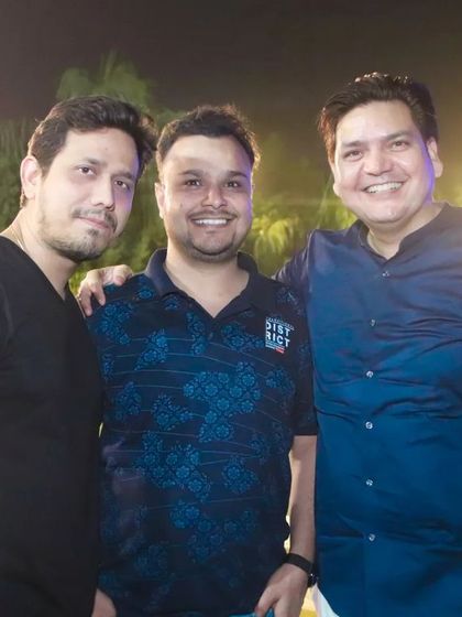 Three friends smiling and posing for a picture at an outdoor event. We ensure our event photography includes great memories of your friends.