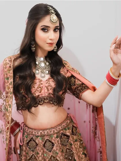 This full-length view showcases a complete bridal ensemble with a soft, romantic feel. Our training emphasizes how to harmonize makeup and hair with the outfit and jewelry.